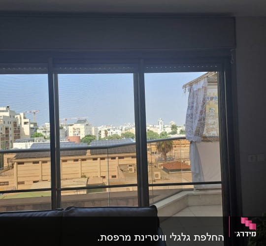תריסים סגורים למחצה על חלון זכוכית גדול